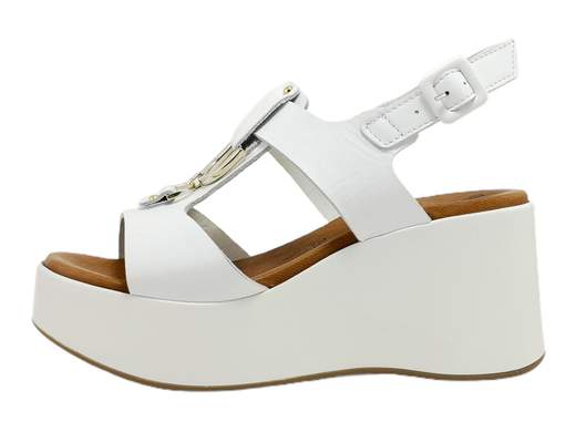 Scopri l'eleganza del sandalo zeppa da donna Susimoda 22330/38. Realizzato in pelle di alta qualità, presenta due fasce adornate da dettagli metallici. Il sottopiede imbottito Piuma Gel garantisce comfort ottimale, mentre la zeppa da 7,5 cm unisce stile e comodità. Un capolavoro Made in Italy che incarna l'artigianalità di alta classe. Entra in un mondo di eleganza e benessere con questo sandalo.