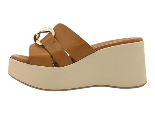 Scopri la perfezione della ciabatta zeppa da donna Susimoda 12230/38. Realizzata interamente in pelle di alta qualità, presenta una grande fascia con elegante accessorio dorato. Il sottopiede imbottito Piuma Gel assicura comfort supremo, mentre la zeppa da 7,5 cm unisce stile e praticità. Progettata e fatta in Italia, rappresenta l'eccellenza artigianale. Entra in un mondo di eleganza e benessere con questa ciabatta.